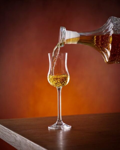 Najboljši recept za dobro travarico 1 pouring alcohol from a crystal decanter into a grappa glass